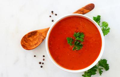 Crema de tomate con perejil, una de las recetas más famosas, servida con una cuchara de madera. Crema de tomate con perejil, una de las recetas más famosas, servida con una cuchara de madera.