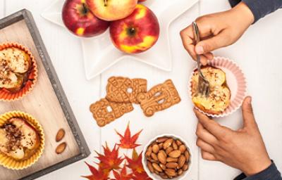 Persona comiendo postre de manzana asada con galletas