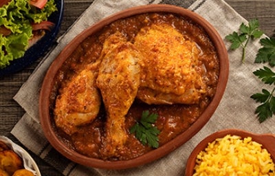Plato de receta de pollo en salsa con ensalada y arroz