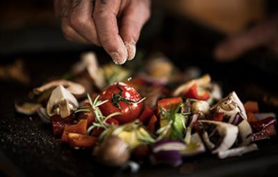 Si unas verduras quedan muy saladas se pueden limpiar con agua Una persona usando sal para sazonar unas verduras.