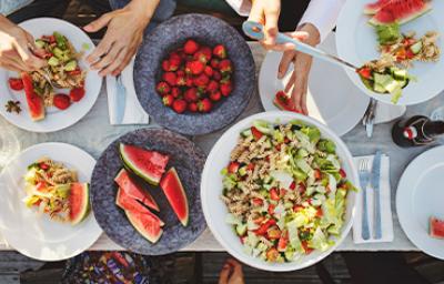 Mesa de picnic con ensalada con pasta y frutas Mesa de picnic con ensalada con pasta y frutas