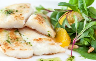 Pescado a la plancha con una ensalada fresca y pequeños brotes