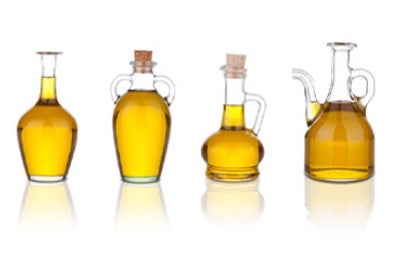 Cuatro jarras con aceite de sésamo en un fondo blanco