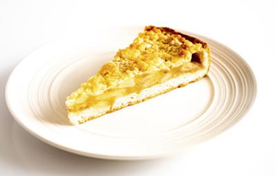Una porción de tarta de lychees y almendras en un plato blanco Una porción de tarta de lychees y almendras en un plato blanco