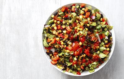 Una ensalada cremosa con maíz, tomate y palta en toma cenital Una ensalada cremosa con maíz, tomate y palta en toma cenital
