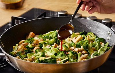 Ensalada de brócoli y hongos aderezada con salsa hoisin en una sartén wok Ensalada de brócoli y hongos aderezada con salsa hoisin en una sartén wok