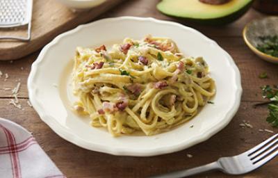 Pasta carbonara con pollo, panceta y hierbas en un plato hondo Pasta carbonara con pollo, panceta y hierbas en un plato hondo