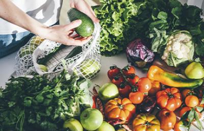 v Una persona sacando productos orgánicos, frutas y verduras de una bolsa