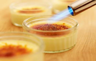 Soplete de cocina caramelizando la superficie de un flan