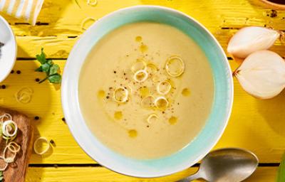 Vichyssoise en un bowl, mesa amarilla con ingredientes frescos Vichyssoise en un bowl, mesa amarilla con ingredientes frescos