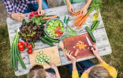 Familia preparando al aire libre ensalada de pulpo