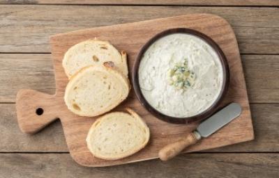 Tabla con rodajas de pan para esparcir salsa gorgonzola Tabla con rodajas de pan para esparcir salsa gorgonzola