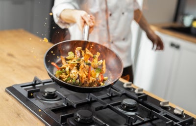 Chef preparando plato de cocina de autor con un salteado de vegetales