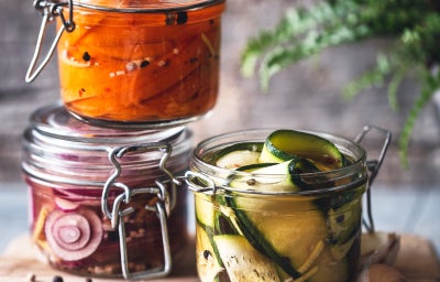 conservas caseras varios tarros de vegetales encurtidos en una mesa.