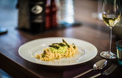 Plato de pasta al pesto bien decorado.