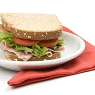 Un sándwich clásico de jamón, lechuga y tomate, uno de los snacks saludables más populares 