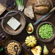 Tofu, granos, semillas y verduras servidas en una mesa, comidas veganas que se suelen usar.