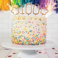 Torta de cumpleaños con chispas de colores y vela  