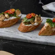 Tapas españolas con tomate, queso crema, albahaca y pollo. 