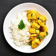 Arroz basmati con pollo al curry y unas hojitas de perejil.