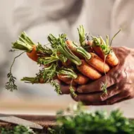 Persona cocinando con zanahorias y creando su plantilla de menú semanal