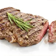 Corte de solomillo cocinado con una receta de hierbas, romero y condimentos sobre un fondo blanco