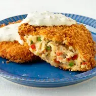 Pastel de pescado partido a la mitad con salsa blanca de yogurt griego