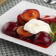 Plato con tipos de ciruela partidas y en almíbar