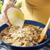 Una persona preparando una receta de cocción lenta con champiñones, crema y arroz