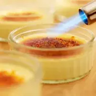 Soplete de cocina caramelizando la superficie de un flan