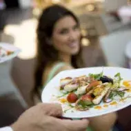 Exquisito y elegante platillo de cualquiera de los tipos de calamar con vegetales siendo llevado a la mesa.