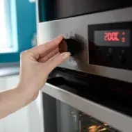 Persona ajustando temperatura en horno, termómetro de cocina