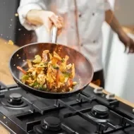 Chef preparando plato de cocina de autor con un salteado de vegetales