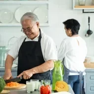 Hombre cortando zanahoria con técnica.