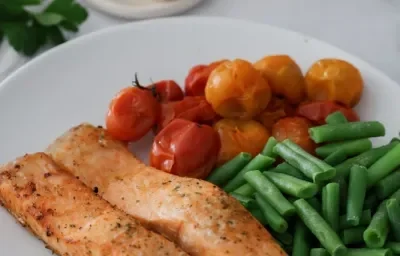 Filetes de salmón en airfryer con tomates cherry asados y chauchas salteadas, sazonado con ajo y cebolla