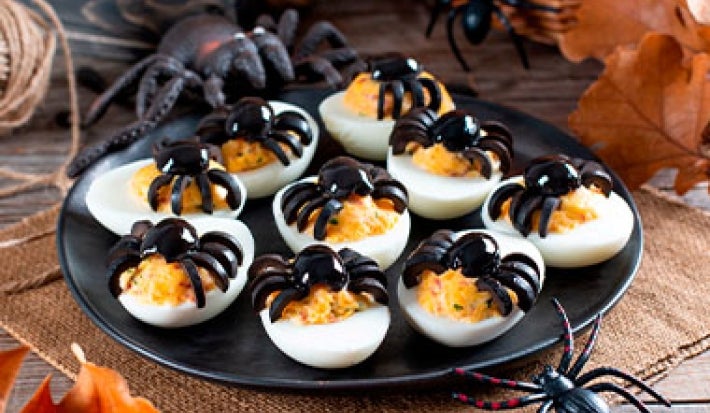 Huevos arácnidos sobre un plato negro para una fiesta de Halloween. Huevos arácnidos sobre un plato negro para una fiesta de Halloween.