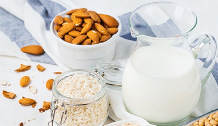 Leche y harina con tazón de almendras enteras sin pelar Leche y harina con tazón de almendras enteras sin pelar