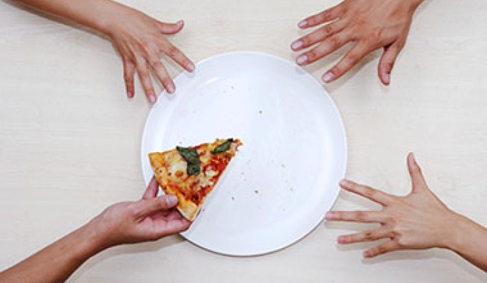 Plato con pizza y manos para calcular porciones de alimentos Plato con pizza y manos para calcular porciones de alimentos