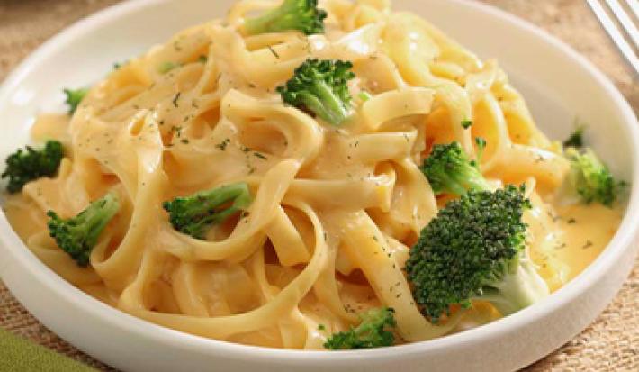 Plato de receta con tallarines en salsa de queso y brócoli Plato de receta con tallarines en salsa de queso y brócoli