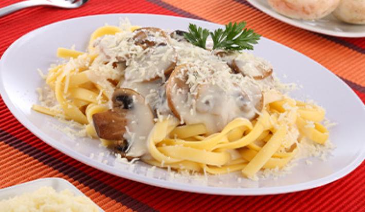 Plato de recetas con tallarines con salsa de champiñones Plato de recetas con tallarines con salsa de champiñones
