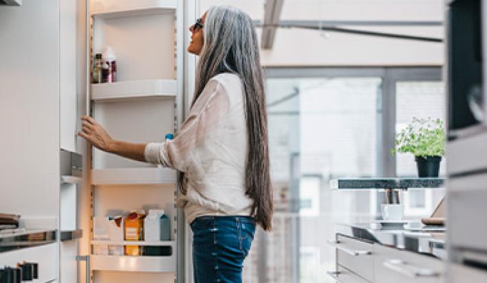 Mujer abriendo puerta de heladera, quitar mal olor de la heladera Mujer abriendo puerta de heladera, quitar mal olor de la heladera