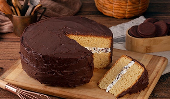 Mesa con torta de cumpleaños de vainilla con cobertura de chocolate Mesa con torta de cumpleaños de vainilla con cobertura de chocolate