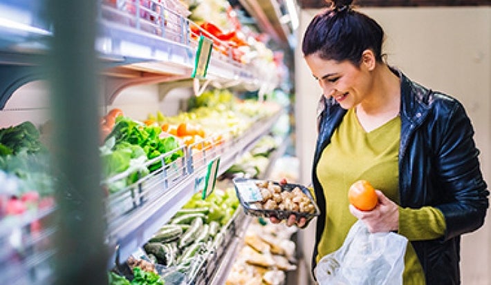 Mujer comprando champiñones y frutas supermercado clasificación alimentos Mujer comprando champiñones y frutas supermercado clasificación alimentos