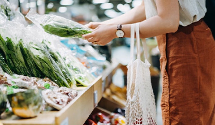 Mujer eligiendo hortalizas en supermercado clasificación alimentos Mujer eligiendo hortalizas en supermercado clasificación alimentos