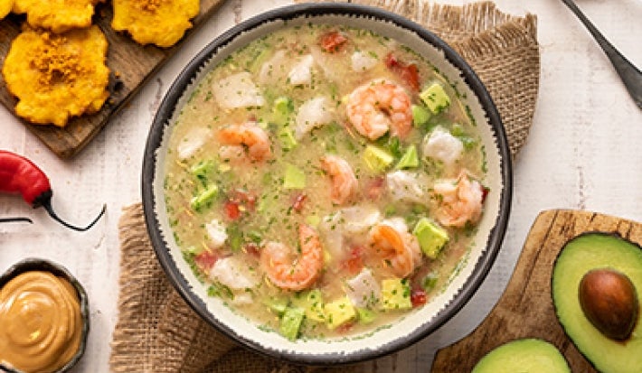 Plato de caldo de pescado con camarones, chiles, plátano y aguacate Plato de caldo de pescado con camarones, chiles, plátano y aguacate