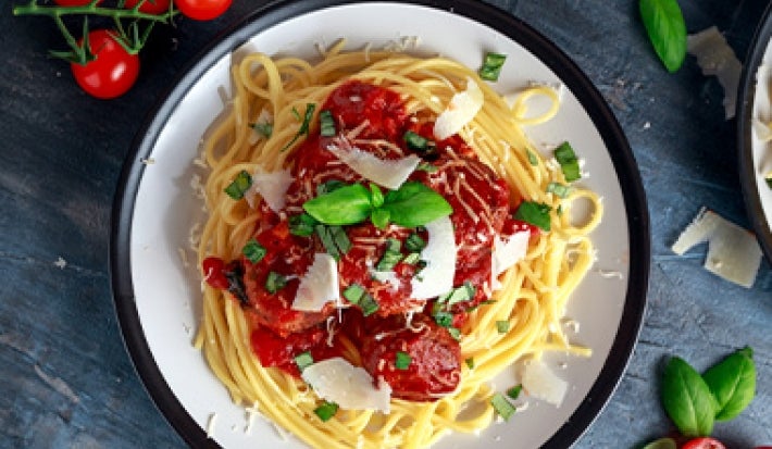 La salsa pomodoro se puede añadir al servir la pasta. Espagueti con salsa pomodoro, queso rallado y hierbas aromáticas.