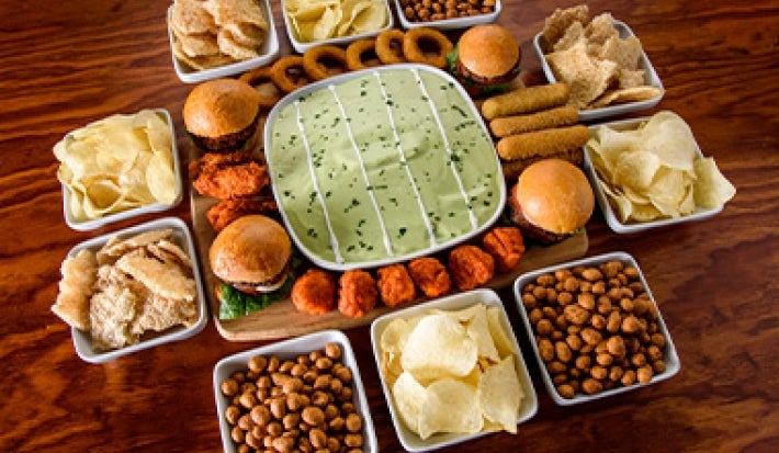 Mesa con snacks fáciles, como frutos secos y papas, para ver deportes. Mesa con snacks fáciles, como frutos secos y papas, para ver deportes.