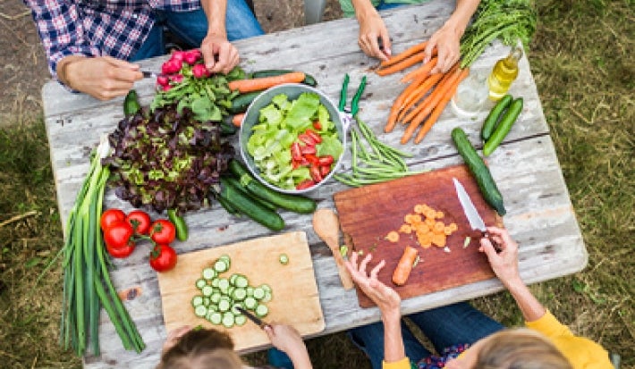 Los tipos de corte se usan con frecuencia en verduras para darle variedad visual a los platos. Familia partiendo verduras con diferentes tipos de corte para preparar una ensalada.